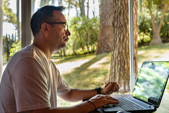 A man working at home, using a laptop.