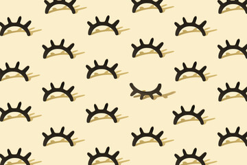 Creative pattern with wooden eyelashes on a pastel yellow backgr