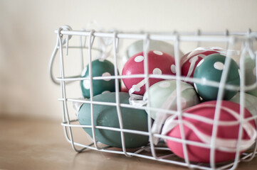 Fototapeta na wymiar Easter eggs of pink and green colors of two shades in a white basket.