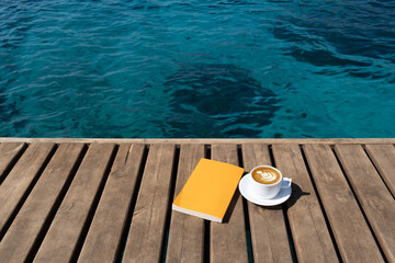 book and coffee cup on wooden background
