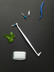dental tools: end-tufted and interdental brushes, floss on backdrop