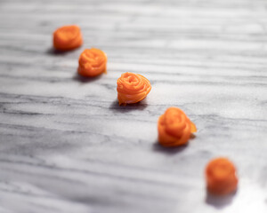 Row of Carrot Roses on White Marble