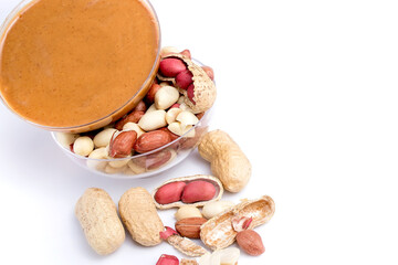 Peanut butter isolated and peanuts in the peel scattered on the white background. Copy space.