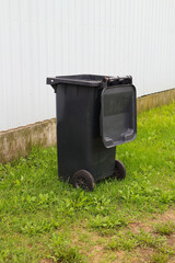 Plastic trash can on the grass . Responsible attitude to the environment.
