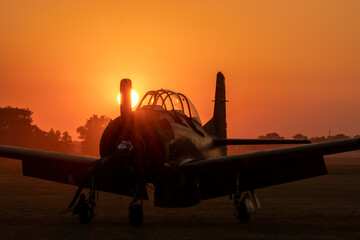 Classic ,military airplane parked in the setting sun