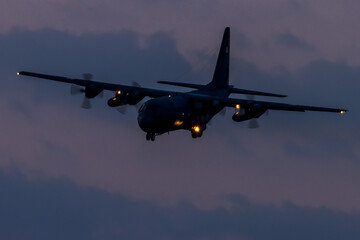 Fototapeta na wymiar Military four-engine aircraft approaching airfield