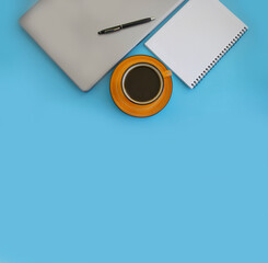 cup of coffee, notepad, laptop on a colored background
