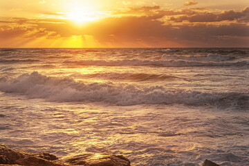 beautiful seascape of sunset with cloudy sky and high surf golden hour