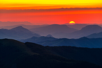 Fototapeta premium Summer sun behind mountain hills