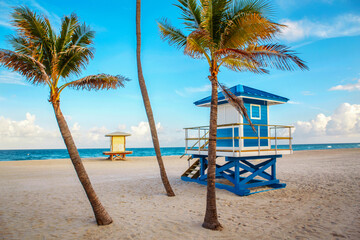 Beautiful Florida landscape with palm trees and blue lifeguard house.