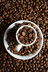 Cup with coffee beans on coffee beans background