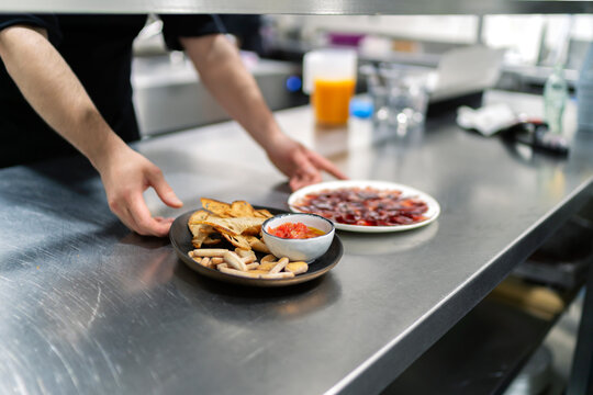 cook serving a plate of freshly cut ham