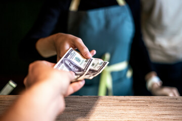 paying dollar cash to the waiter in cafe - obrazy, fototapety, plakaty