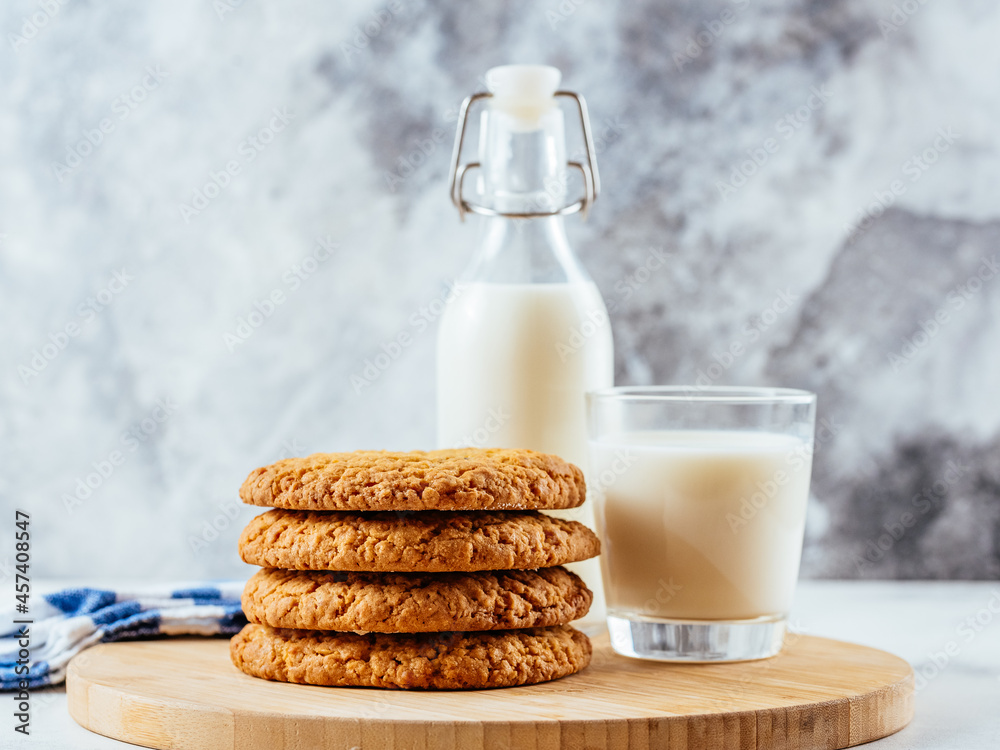 Wall mural homemade oatmeal cookies on a light background with milk in a gl