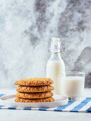 homemade oatmeal cookies on a light background with milk in a gl