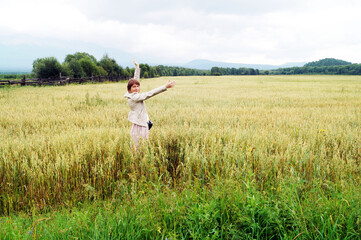 A 35-40-year-old woman in a field in the Sayan Mountains