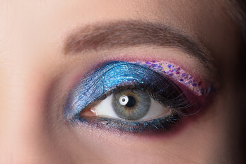 Closeup of female eye with bright shiny purple shadows