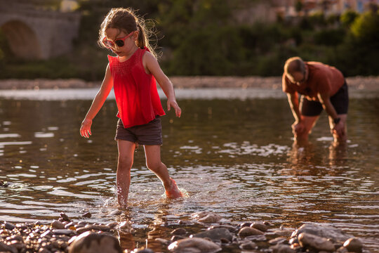 Father and daughter play in river in south of France in summer