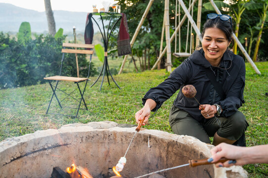 woman heating up marshmallows over camp fire in the Golden Triangle