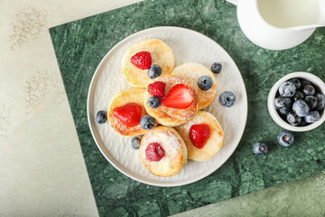 Plate with tasty cottage cheese pancakes and berries on table
