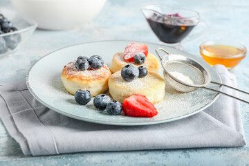 Plate with tasty cottage cheese pancakes and berries on table