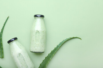 Bottles of healthy aloe juice on color background