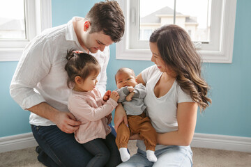Happy family with children at home. Older sister meet newborn brother