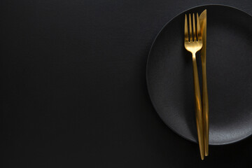 Golden cutlery set with dark plate - 457413943