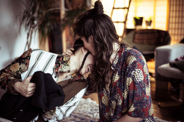 Alternative young couple laugh in playful and intimate embrace