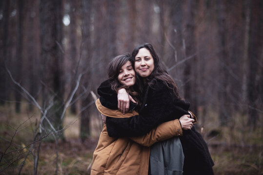 Happy girlfriends hug and smile outdoors in the forrest in germany