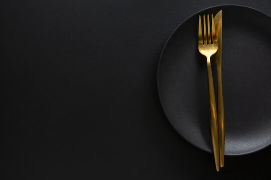 Golden cutlery set with dark plate