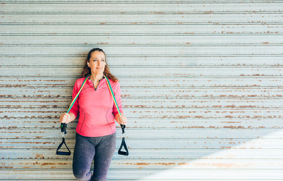 Woman doing a workout with elastic bands in a gym.