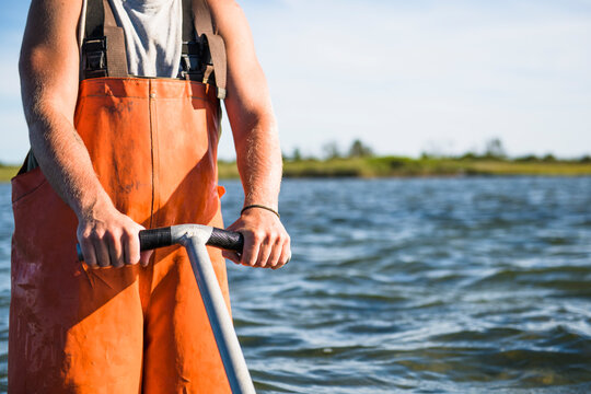 Young man working on the water in aquaculture oyster farm