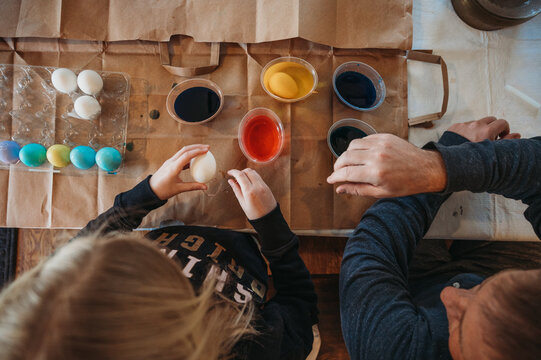 Overhead View of Girl and Father dyeing Easter eggs
