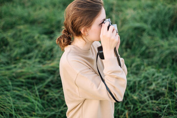 Pretty woman holding film camera in a field