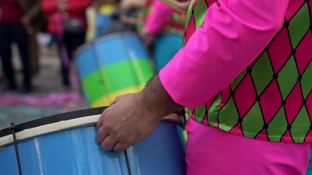 A group of drummers playing rhythmic music during the parade at the carnival. Dressed in colorful traditional costumes.