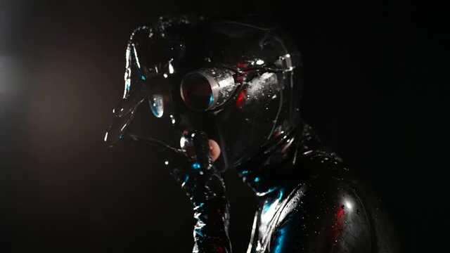 female bdsm lover in black latex bodysuit and full face mask, costume for bdsm role playing