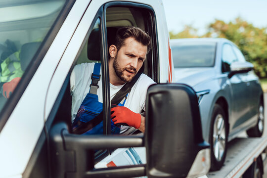 Handsome middle age man working in towing service on the road. Roadside assistance concept.