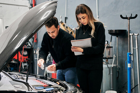 Two mechanics help each other in the work of a garage