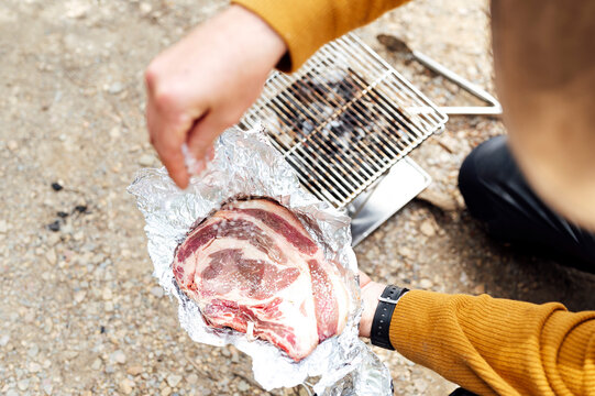 Barbecue man putting salt on meat