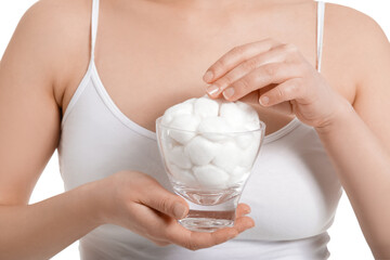 Beautiful young woman with cotton wool on white background, closeup