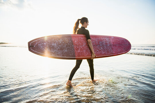 Woman friends going for a sunrise summer surf