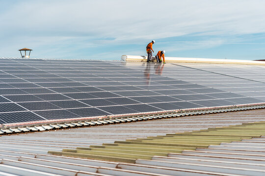 Unrecognizable solar panel technicians working on a Spanish factory
