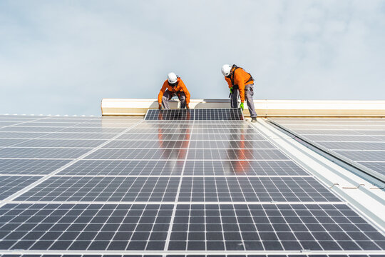 Unrecognizable solar panel technicians teamworking in Spanish factory