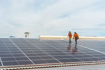 Unrecognizable solar panel technicians walking in Spanish installation