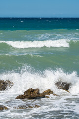 Fototapeta na wymiar In rushing waves hitting rocks and beach