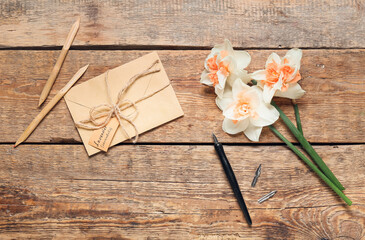 Envelope with text LAVENDER LAVANDULA, pens and flowers on wooden background