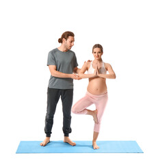 Young pregnant woman and her husband practicing yoga on white background