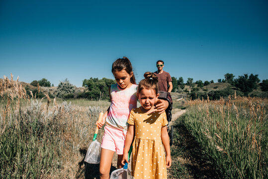 Big sister consoles little sister when she cries on a nature walk