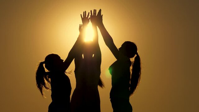 Silhouette Team of people greet each other with raised hands, handshake, partners agreed. Group of people hands.Teamwork, workers, out put your hands up. Team in company working partnership business.